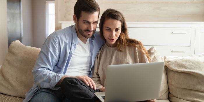 Couple researching adoption agency on computer